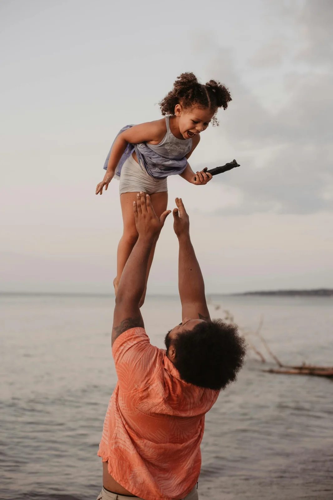 Dad throwing his child into the air on the beach
