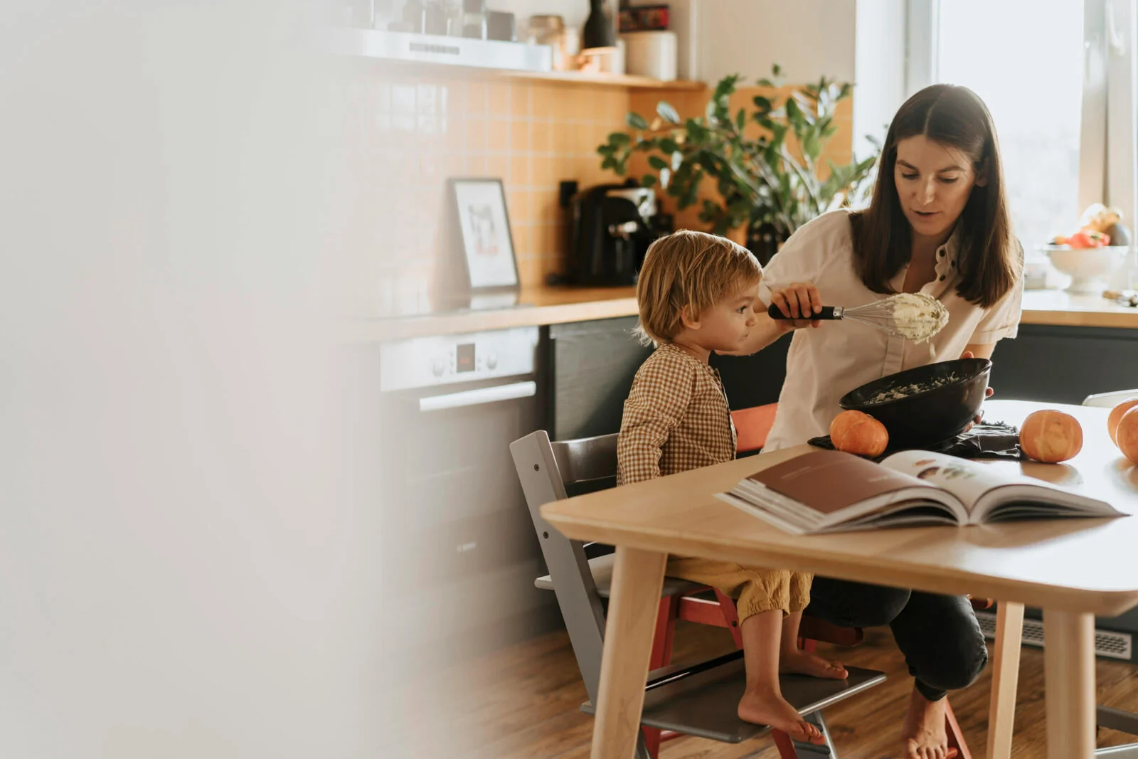 Mother and toddler baking together at a kitchen table