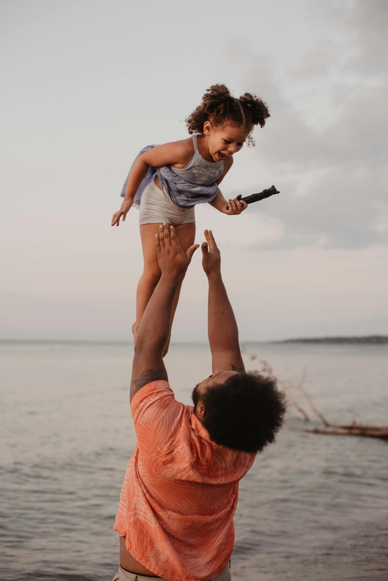 Dad throwing his child into the air on the beach